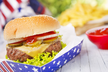 Burger with fries on an outdoor table in bright light