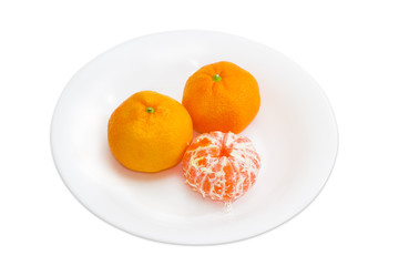 Two whole and one peeled mandarin orange on a white dish