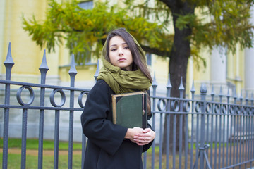 the girl walks down the street with a book