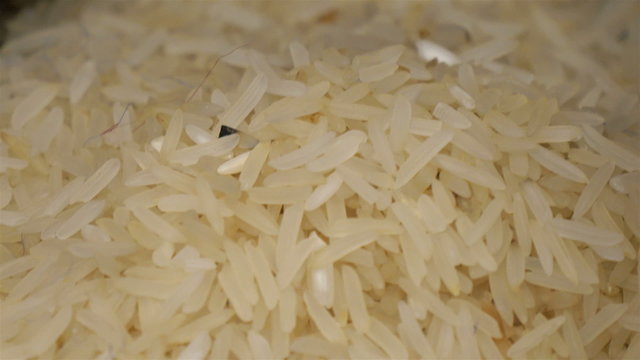 The white rice grains in the container. Closer look of the rie grains that is sold in the market