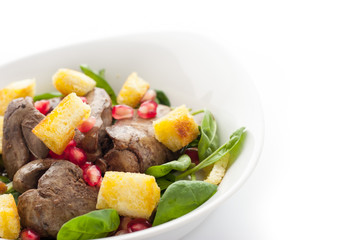 Salad with chicken liver and spinach in the white plate horizontal