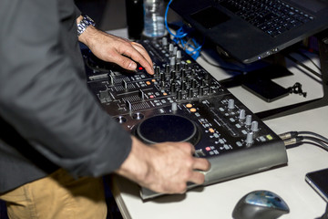 Dj mixes the track in the nightclub at party