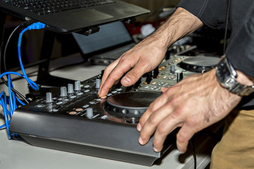 Dj mixes the track in the nightclub at party