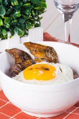 salted dried fish and fried fresh egg on top of purple rice