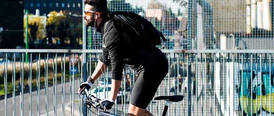 Fototapeta premium Cyclist profile portrait riding bicycle in the city letterbox