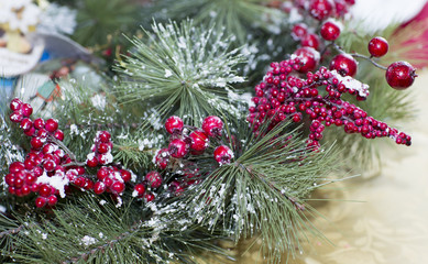 Artificial twig on wooden background. Christmas branch with berries in the snow. 