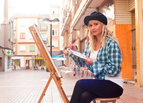girl painting a picture on the street