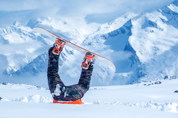 Legs of a snowboarder stuck in snow