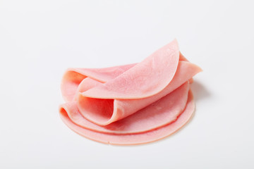 Thin slices of ham on white background