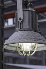 street industrial led lamp under snow closeup