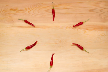 six hot chili peppers on a wooden table background, place for te