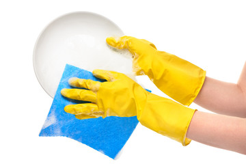 Close up of female hands in yellow protective rubber gloves washing white plate with blue rag against white background