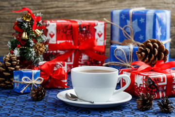 Christmas table with cup of tea and gifts.