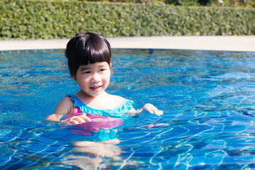 Fototapeta na wymiar Cute Asian girl enjoy in swimming pool