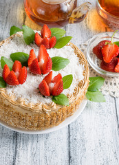 Celebratory cake with strawberry flowers and tea