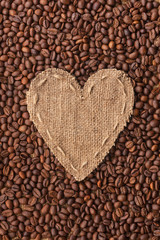 Frame in the shape of heart made of burlap with coffee beans