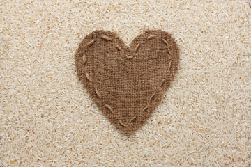 Frame in the shape of heart made of burlap with rice