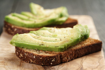 toasted rye bread with sliced avocado and herbs