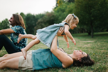 Happy young hipster family having fun while running, bowl,  rising up, piggyback ride their...