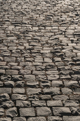 Hintergrund - historisches Kopfsteinpflaster aus Basalt im Gegenlicht perspektivisch