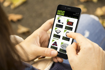 woman with outlet online shop phone in the park