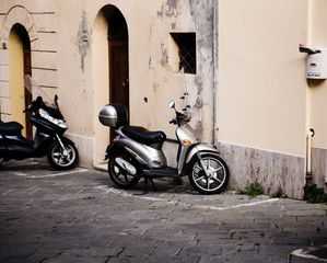 Fototapeta na wymiar motor scooter parked in front of a building wall