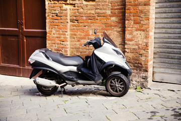 motor scooter parked in front of a building wall