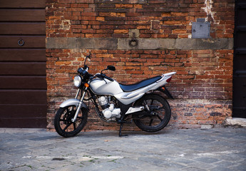 Fototapeta na wymiar motor scooter parked in front of a building wall
