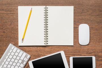 Office wooden table with notebook, yellow pencil, tablet, keyboard
