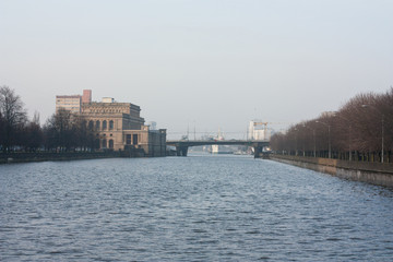 Fototapeta premium Old renovated / City landscape on the river, the house of culture of sailors and bridge. Russia, Kaliningrad.