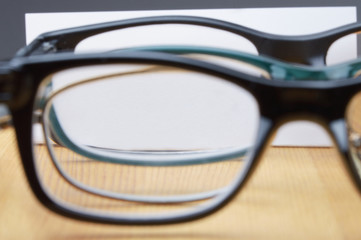 Fototapeta na wymiar mehrere Brillen zeigen ein blanco Papier