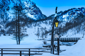 Illuminated lamp on snowcapped landscape