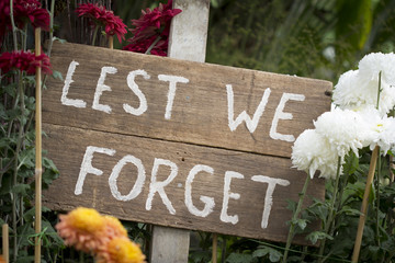 ANZAC saying "Lest We Forget" on Wooden Sign in Garden