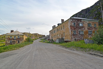 Fototapeta na wymiar The street with the thrown houses in the settlement of Teriberka