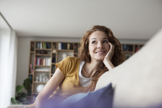 Smiling woman at home sitting on couch