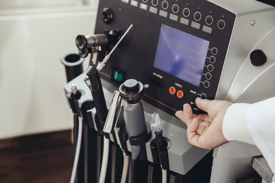 ENT doctor turning a knob at medical device in practice