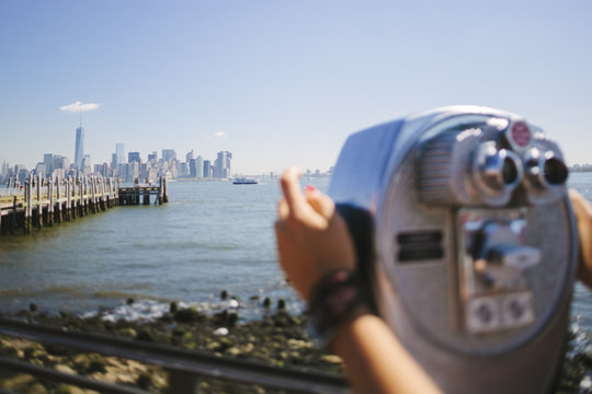 USA, New York City, view to the skyline with person using coin operated binoculars in the foreground