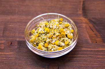 Chamomile flower on bowl on wooden table