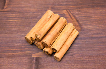 Cinnamon sticks on a wooden table seen from above