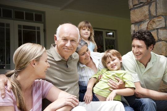 Group picture of three generations family sitting on the terrace