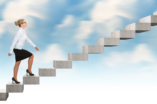 Business woman walking up a staircase. blue sky background
