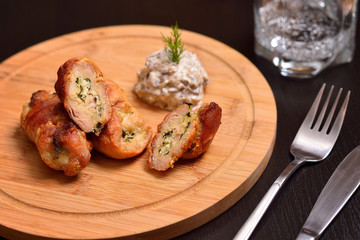 roulade of turkey with cheese and spinach on wooden board