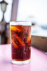 Cold cola soda drink in glass with condensation