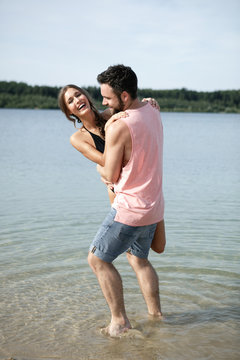 Germany, Haltern, young couple relaxing at Silbersee