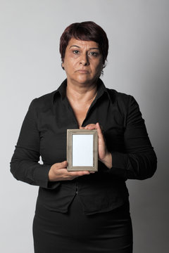 Unhappy Middle Aged Woman Holding Photo Frame