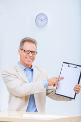 Smiling businessman showing his records. 