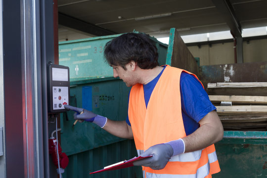 Worker at a waste container operating machine