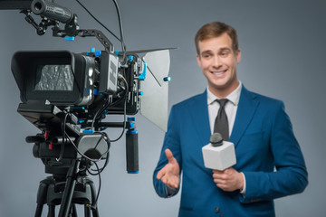 Smiling newsman with a microphone. 