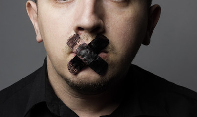 man with mouth covered by black patch to forbidden him the free - obrazy, fototapety, plakaty