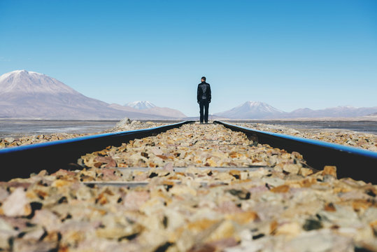 Bolivia, Potosi, Man walking the railroad tracks through the Bolivian Altiplano